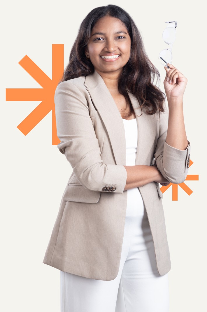 Chamathka smiling, holding her glasses